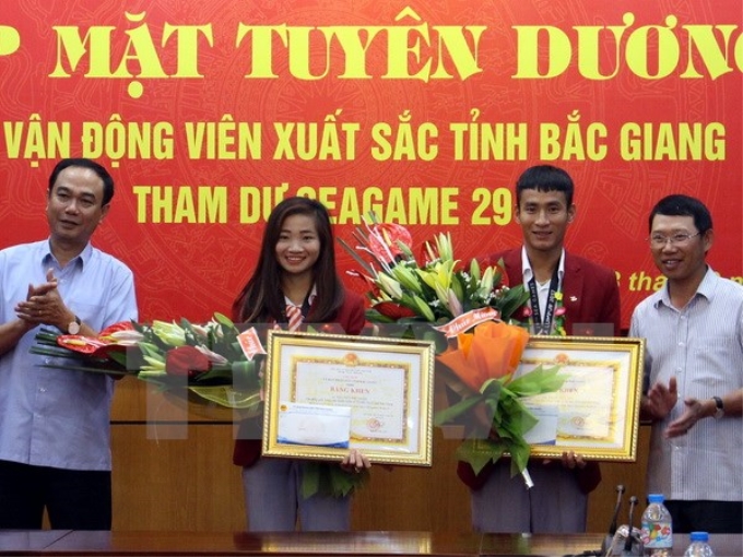 Phó Chủ tịch UBND tỉnh Bắc Giang Lê Ánh Dương (bên phải) khen thưởng cho các vận động viên. (Ảnh: TTXVN)