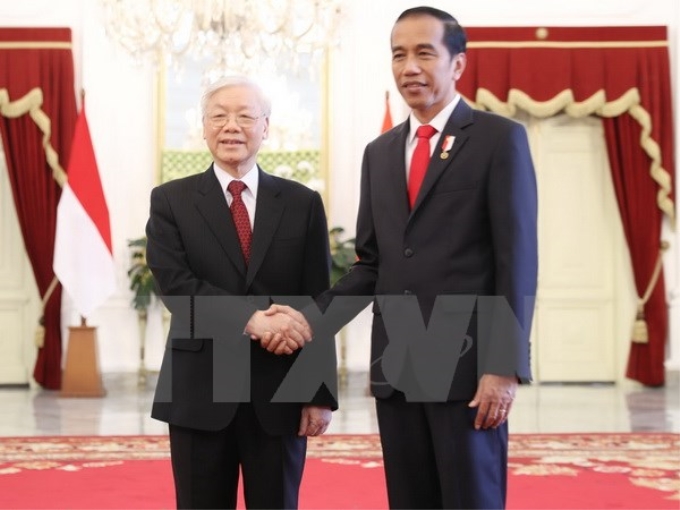 Tổng thống Indonesia Joko Widodo đón Tổng Bí thư Nguyễn Phú Trọng. (Ảnh: Trí Dũng/TTXVN)