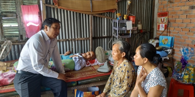 Ông Nguyễn Tuấn Anh, Giám đốc Điện lực huyện Châu Thành hỏi thăm ông Mai Văn Chẵn (76 tuổi)  ông ngoại của cháu Nguyễn Thị Ngọc Lan