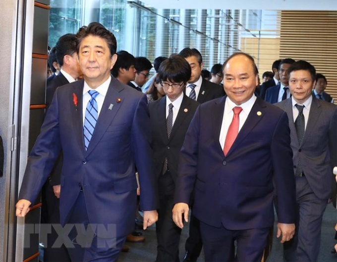 Thủ tướng Nguyễn Xuân Phúc và Thủ tướng Nhật Bản Shinzo Abe chuyển sang phòng họp báo sau khi kết thúc hội đàm. (Ảnh: Thống Nhất/TTXVN)