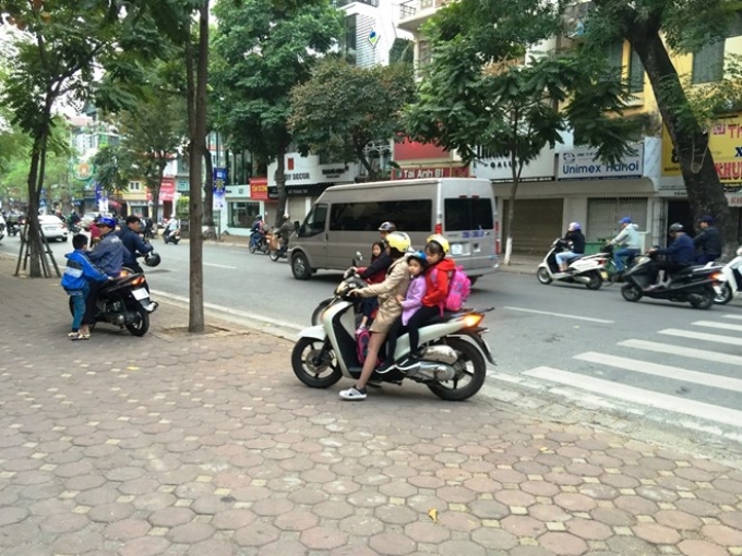 Nhiều cha mẹ học sinh nghiêm túc chấp hành đúng Luật giao thông. (Ảnh: Việt Hùng/Vietnam+)