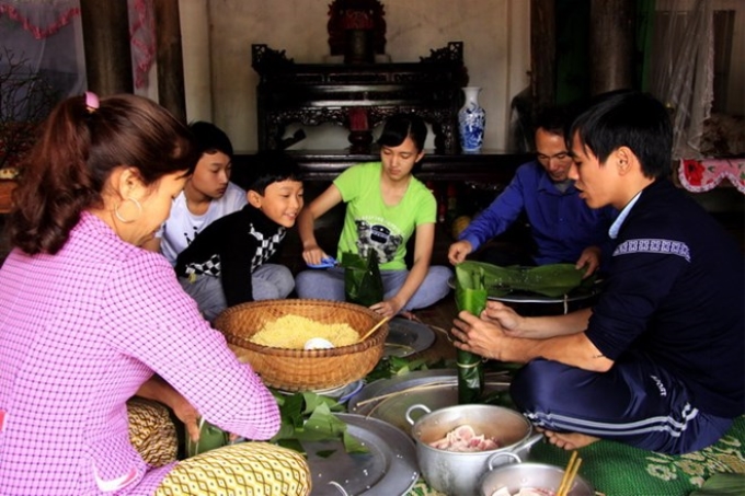 Các thành viên trong gia đình cùng tham gia gói bánh mang lại bầu không khí ấm cúng, vui vẻ. (Ảnh: TTXVN)