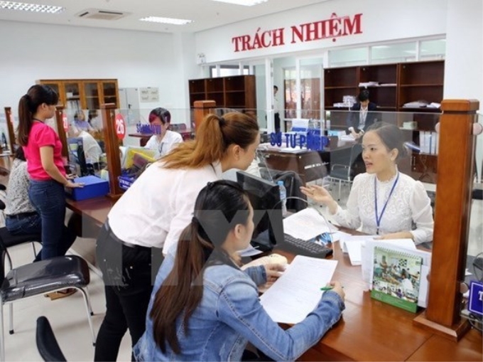 Hướng dẫn người dân giải quyết thủ tục hành chính tại khu vực giao dịch một cửa điện tử ở Trung tâm hành chính Đà Nẵng. (Ảnh minh họa: TTXVN)