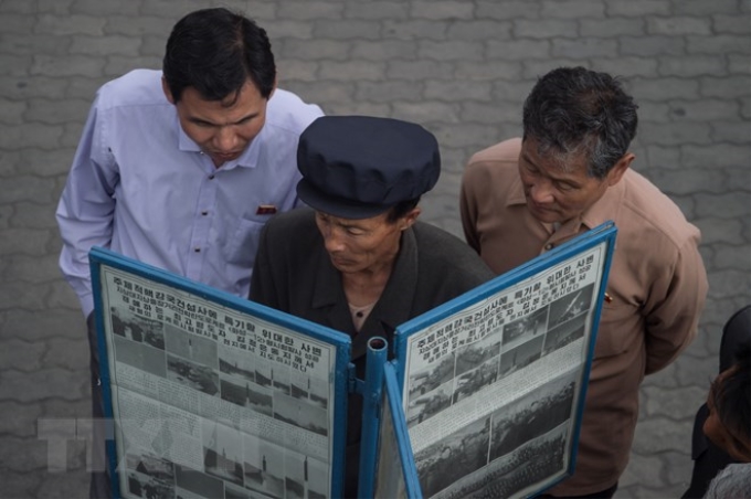 Người dân đọc báo Rodong Sinmun tại thủ đô Bình Nhưỡng. (Nguồn: AFP/ TTXVN)