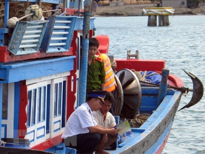 Lực lượng chấp pháp trên biển của Ninh Thuận tuyên truyền cho ngư dân về các quy định pháp luật trong đánh bắt hải sản (Ảnh: TTXVN)