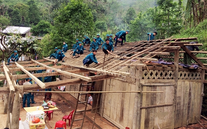 Lực lượng dân quân giúp người dân xã Nghiên Loan, huyện Pắc Nặm sửa chữa nhà sau mưa đá.