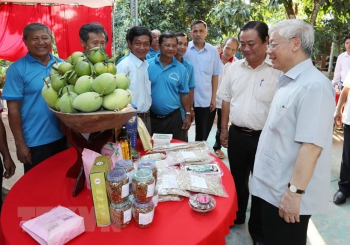 Tổng Bí thư Nguyễn Phú Trọng xem các sản phẩm nông nghiệp tại Tâm Quê Hội Quán, xã Tân Thuận Tây, thành phố Cao Lãnh, tỉnh Đồng Tháp. (Nguồn: TTXVN)