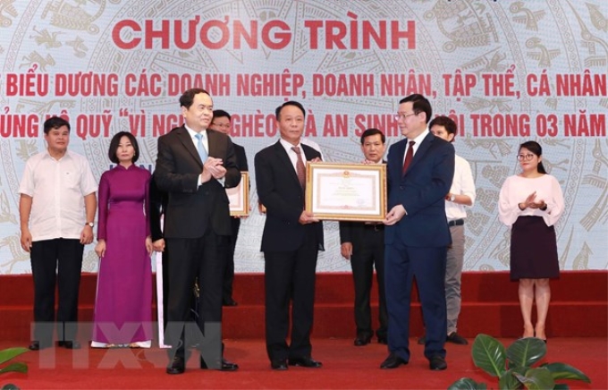 Ông Vương Đình Huệ, Ủy viên Bộ Chính trị, Phó Thủ tướng Chính phủ, Trưởng ban Chỉ đạo Trung ương các Chương trình mục tiêu Quốc gia và Đồng chí Trần Thanh Mẫn, Bí thư Trung ương Đảng, Chủ tịch Ủy ban Trung ương Mặt trận Tổ quốc Việt Nam trao Bằng khen của Thủ tướng Chính phủ cho các cá tập thể có thành tích xuất sắc. (Ảnh: Doãn Tấn/TTXVN)