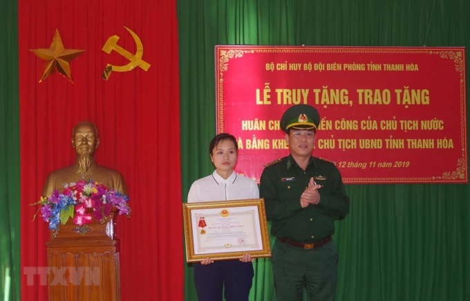 Vợ thiếu tá Vi Văn Nhất đón nhận Huân chương Chiến công hạng Nhất. (Ảnh: Trịnh Duy Hưng- TTXVN)
