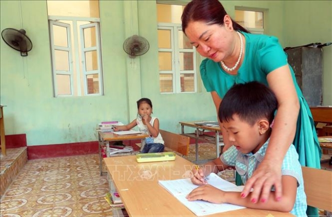 Cô giáo Vũ Thị Hà đang hướng dẫn học sinh lớp 2, Trường tiểu học Bạch Long Vỹ, học bài.