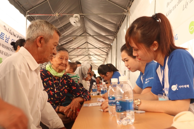 Các tình nguyện viên của chương trình hướng dẫn người dân các thủ tục khám bệnh.