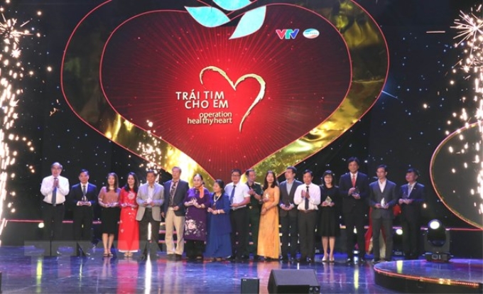 Tặng Kỷ niệm chương cho một số nhà hảo tâm đã tích cực tham gia Chương trình "Trái tim cho em". (Ảnh: Xuân Khu/TTXVN)
