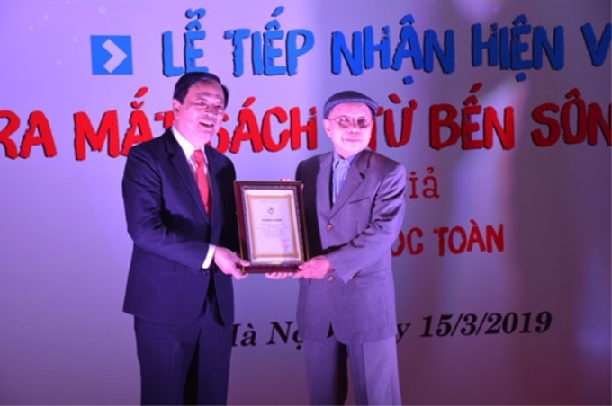 Phó Chủ tịch Hội Nhà báo Việt Nam Mai Đức Lộc chụp ảnh lưu niệm với cá nhân hiến tặng hiện vật cho Bảo tàng Báo chí Việt Nam. Ảnh: Huy Hoàng