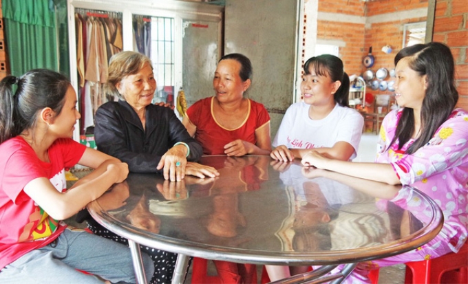 Bà Nguyễn Thị Theo (ngồi giữa) tích cực đến nhà các hộ dân vận động, tuyên truyền. Ảnh: cát Tường