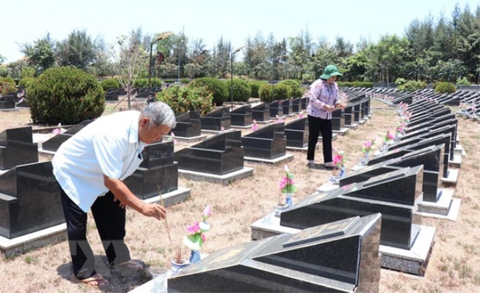 Ông Huỳnh Đồng (nguyên Trung đội trưởng Trinh sát-Đoàn 10) và bà Phạm Thị Nhung (cán bộ y tá Đoàn 10) thắp nhang cho các đồng đội tại Nghĩa trang Liệt sỹ Rừng Sác. (Ảnh: Xuân Khu/TTXVN)