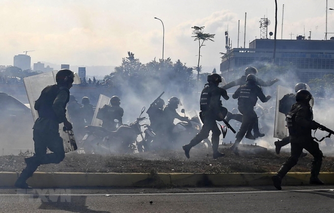 Lực lượng trung thành với Tổng thống Venezuela Nicolas Maduro ngăn các tay súng thuộc nhóm binh sĩ ủng hộ thủ lĩnh đối lập Juan Guaido nổi dậy tại căn cứ quân sự La Carlota ở Caracas ngày 30/4/2019. (Ảnh: AFP/TTXVN)