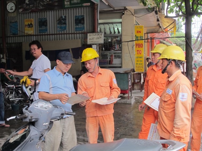 Nhân viên EVN Hà Nội tuyên truyền sử dụng điện an toàn, tiết kiệm. (Ảnh: Vietnam+)