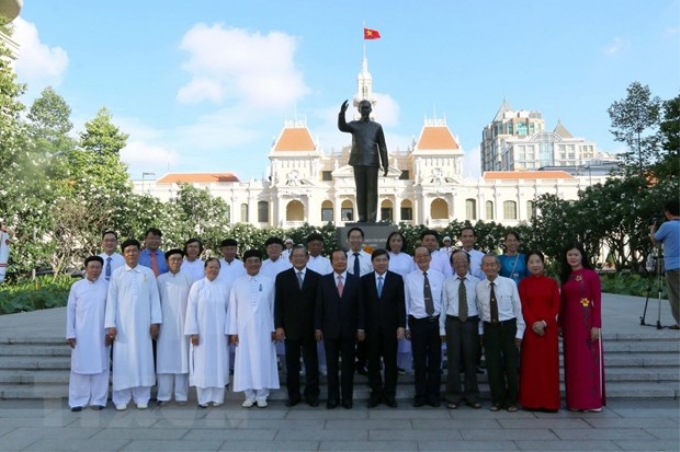 Lãnh đạo, nguyên lãnh đạo Thành phố Hồ Chí Minh chụp ảnh lưu niệm cùng các nhân sỹ tri thức, chức sắc tôn giáo, đại biểu dân tộc tại Công viên Tượng đài Chủ tịch Hồ Chí Minh (quận 1). (Ảnh: Thanh Vũ/TTXVN)