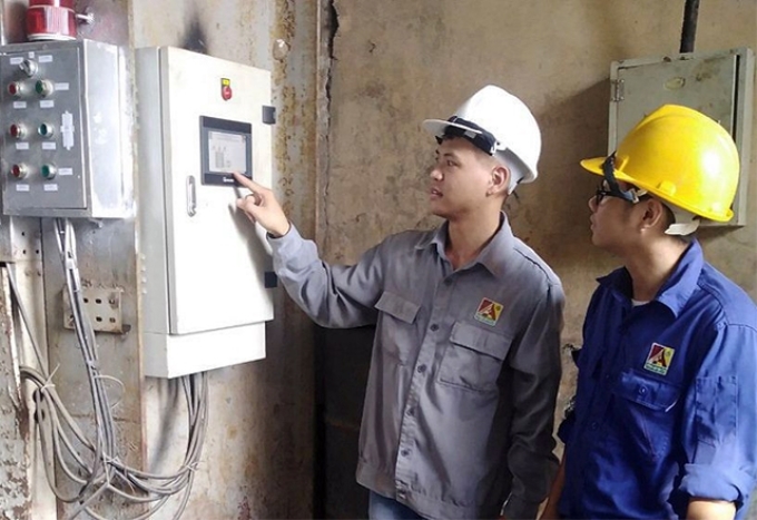 Kỹ sư Vũ Hà Minh (bên trái) hướng dẫn công nhân thao tác, vận hành thiết bị.