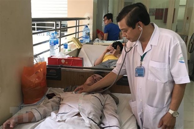 Bác sỹ Bệnh viện Bệnh Nhiệt đới Thành phố Hồ Chí Minh khám bệnh, điều trị cho bệnh nhân mắc sốt xuất huyết. (Ảnh: Đinh Hằng/TTXVN)