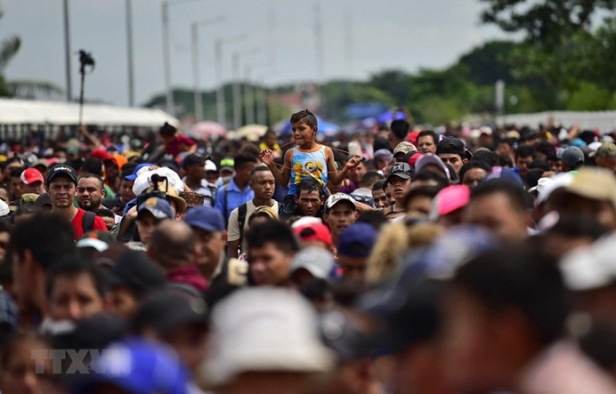 Người di cư trong hành trình tới Mỹ tại cây cầu biên giới Guatemala-Mexico. (Ảnh: AFP/TTXVN)