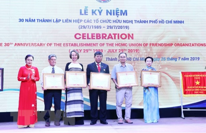 Bà Nguyễn Phương Nga, Chủ tịch Liên hiệp các tổ chức hữu nghị Việt Nam (VUFO - ngoài cùng bên trái) trao tặng Bằng khen của VUFO cho đại diện một số tổ chức thuộc Liên hiệp các tổ chức hữu nghị Thành phố Hồ Chí Minh. (Ảnh: Xuân Khu/TTXVN)