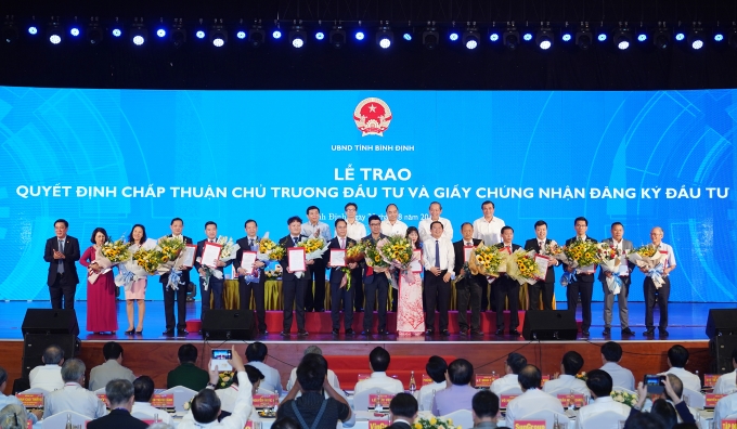 Thủ tướng chứng kiến lãnh đạo tỉnh Bình Định trao quyết định chấp thuận chủ trương đầu tư, giấy chứng nhận đăng ký đầu tư cho 15 dự án. Ảnh: VGP/Quang Hiếu