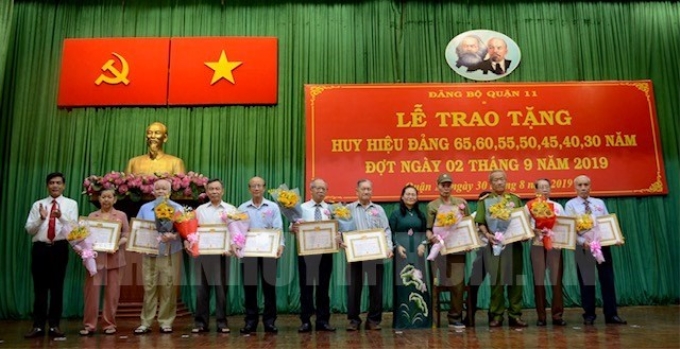 Chủ tịch HĐND TPHCM Nguyễn Thị Lệ và Bí thư Quận ủy Ngô Văn Luận trao Huy hiệu Đảng cho các đồng chí tròn tuổi Đảng