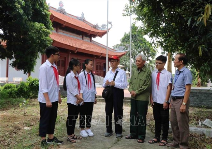 Nhà giáo nhân dân, Anh hùng lao động Nguyễn Đức Thìn (thứ 4 từ trái) tuyên truyền lịch sử với các em học sinh tại Đình Bảng, thị xã Từ Sơn, tỉnh Bắc Ninh. Ảnh: Thái Hùng/TTXVN
