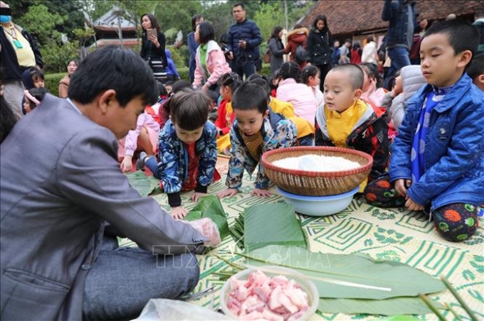 Các em nhỏ hứng thú trải nghiệm "Gói bánh chưng ngày Tết". Ảnh: Thành Đạt/TTXVN