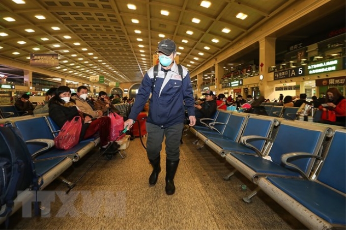 Nhân viên y tế phun thuốc khử trùng tại một nhà ga ở Trung Quốc. (Ảnh: AFP/TTXVN)