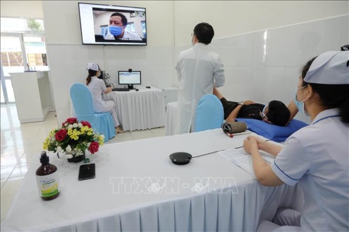 Thăm khám trực tuyến có sự tham gia của các y, bác sĩ Bệnh viện Đại học Y Hà Nội và Bệnh viện 199. Ảnh: TTXVN phát