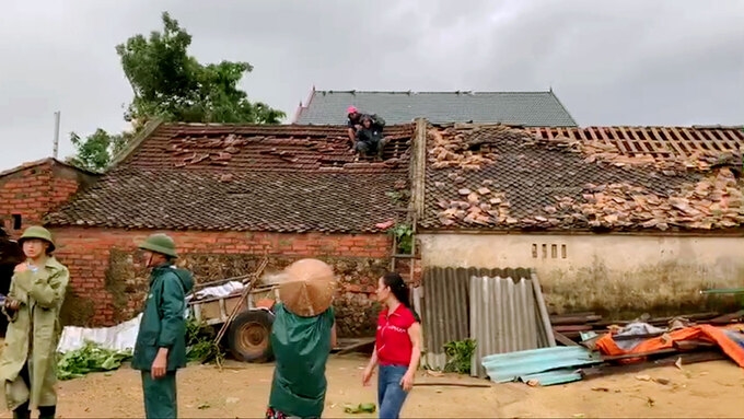 Người dân lợp lại mái nhà sau trận lốc. Ảnh: Đức Hùng