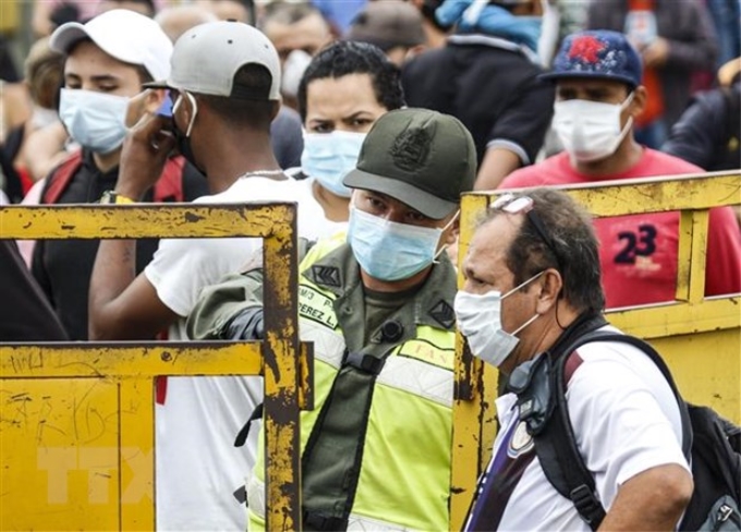 Người dân từ Venezuela chờ nhập cảnh tại khu vưc biên giới Colombia và Venezuela, ngày 12/3. (Ảnh: AFP/TTXVN)