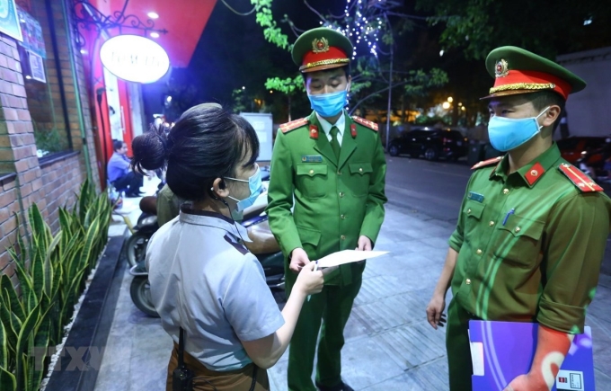 Lực lượng chức năng phường Nguyễn Du đến nhắc nhở các cửa hàng đóng cửa theo quy định. (Ảnh: Minh Quyết/TTXVN)