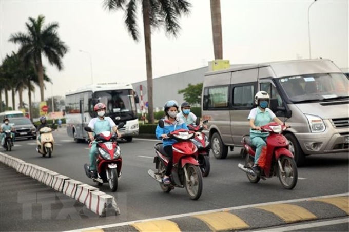 Công nhân quay trở lại làm việc tại khu công nghiệp Thăng Long, Hà Nội. (Ảnh: Danh Lam/TTXVN)