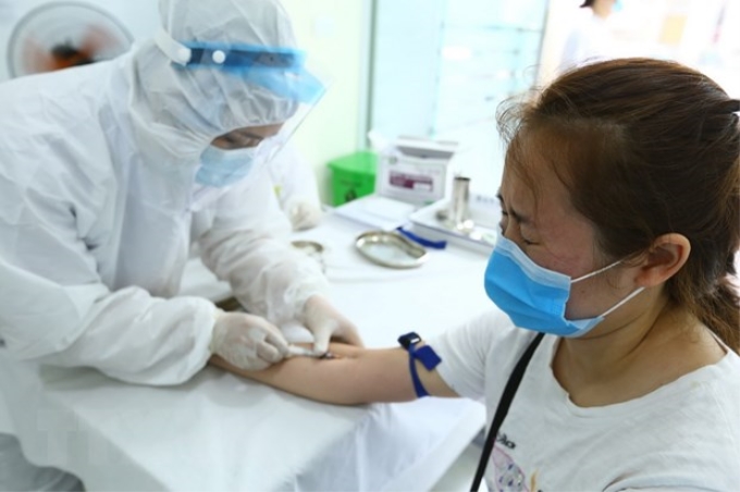 Nhân viên y tế Hà Nội lấy mẫu xét nghiệm nhanh cho người về từ Đà Nẵng sáng 01/8/2020. (Ảnh: Minh Quyết/TTXVN)