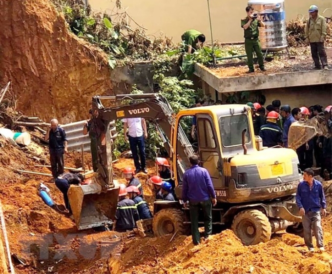 Lực lượng cứu hộ cứu nạn tìm kiếm thi thể nạn nhân trong vụ tai nạn. (Ảnh: Trung Kiên/TTXVN)