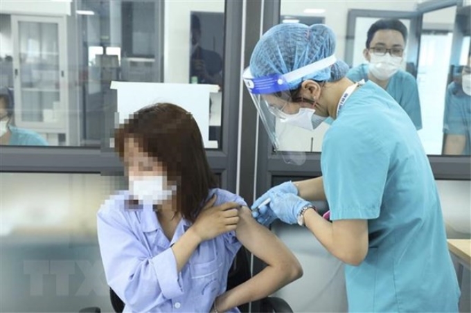 Đội tiêm chủng của Bệnh viện Đại học Y Hà Nội tiêm vaccine phòng COVID-19 cho người bệnh và người nhà đủ điều kiện tiêm chủng chuyển đến từ bệnh viện Việt Đức. (Ảnh: Đức Trọng/TTXVN)