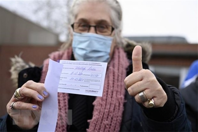 Một người dân nhận giấy Chứng nhận tiêm vaccine ngừa COVID-19 tại Overijse, Bỉ ngày 18/2/2021. (Ảnh: AFP/TTXVN)