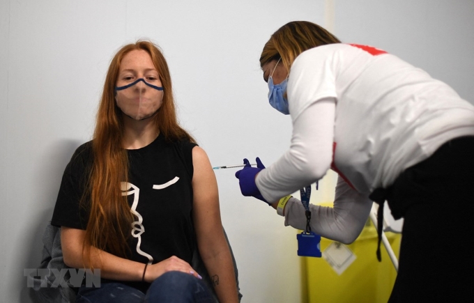 Nhân viên y tế tiêm vaccine ngừa COVID-19 của hãng Pfizer cho người dân tại London. (Ảnh: AFP/TTXVN)