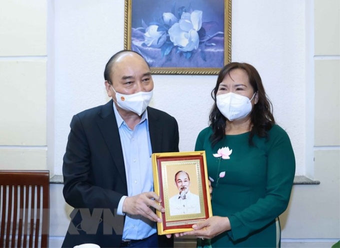 Chủ tịch nước Nguyễn Xuân Phúc thăm tặng quà cho thạc sỹ nhà giáo Triệu Thị Huệ, sinh năm 1965, sống tại phường 15, Quận 5, TP Hồ Chí Minh. (Ảnh: Thống Nhất)
