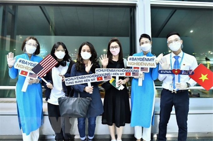 Hành khách chúc mừng Vietnam Airlines mở đường bay thường lệ đến Mỹ. (Ảnh: TTXVN)