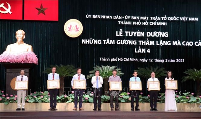 Ông Nguyễn Thành Phong, Chủ tịch Ủy ban nhân dân Thành phố Hồ Chí Minh (thứ 4 từ trái sang) trao Bằng khen của Thủ tướng Chính phủ cho các cá nhân, tập thể có thành tích xuất sắc trong phòng, chống COVID-19.