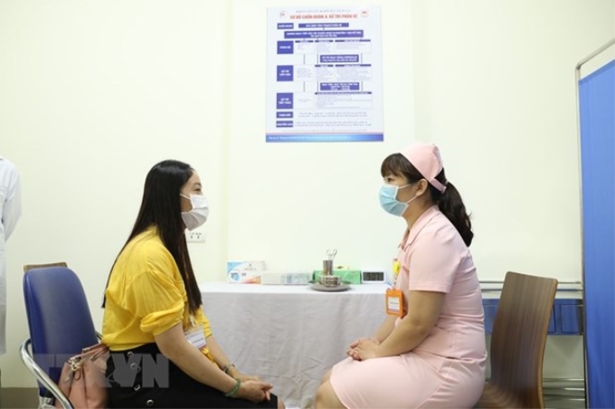 Tư vấn cho tình nguyện viên đầu tiên tham gia tiêm thử nghiệm vaccine COVIVAC. (Ảnh: Minh Quyết/TTXVN)