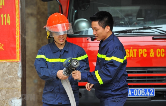 Trung úy Vũ Ngọc Hoàng (phải) hướng dẫn nghiệp vụ cho chiến sỹ mới tại đơn vị. (Ảnh: Minh Đức/TTXVN)