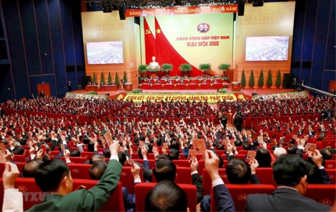 Các đại biểu biểu quyết, thông qua Nghị quyết Đại hội XIII Đảng Cộng sản Việt Nam. (Ảnh: TTXVN).