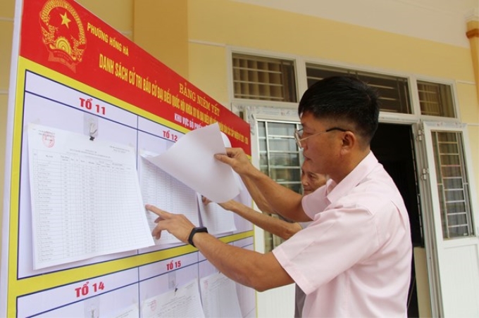 Người dân khu 9, phường Hồng Hà, thành phố Hạ Long, xem danh sách cử tri niêm yết tại nhà văn hóa khu.
