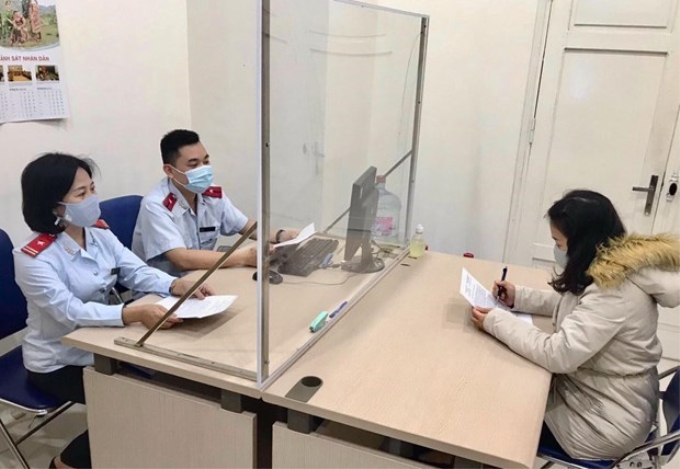 Thanh tra Sở Thông tin và Truyền thông Hà Nội làm việc với chị Hoàng Thu Trang - người có hành vi đăng tin sai sự thật về dịch COVID-19. (Ảnh: TTXVN phát)