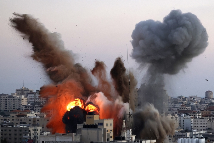 Thế giới đang trải qua những biến động to lớn...., xung đột cục bộ tiếp tục diễn ra dưới nhiều hình thức, phức tạp và quyết liệt hơn (Trong ảnh: Khói lửa bốc lên từ toà nhà có liên quan đến Phong trào Hamas của Palestine, sau khi trúng oanh tạc của máy bay Israel xuống Dải Gaza, trong cuộc giao tranh quân sự dữ dội giữa Israel và lực lượng Hamas, ngày 14-5-2021_Ảnh: AFP/TTXVN)